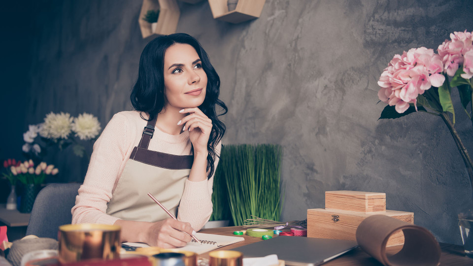 Woman working at a desk in a flower shop.